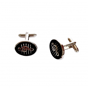 Pair of cufflinks on white surface, one facing camera and one angled slightly left displayed on white background by Ari D Norman