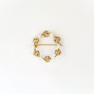 A 9ct yellow gold circle brooch of six 3.8mm pearls & six gold double knots alternately equally spaced in a circle, picture shows front view.