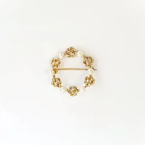 A 9ct yellow gold circle brooch of six 3.8mm pearls & six gold double knots alternately equally spaced in a circle, picture shows front view.