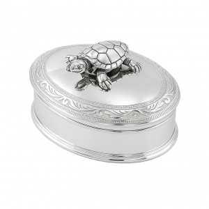 Polished oval silver box with hinged lid, scroll border, and movable turtle on top. Shown on a plain white background.