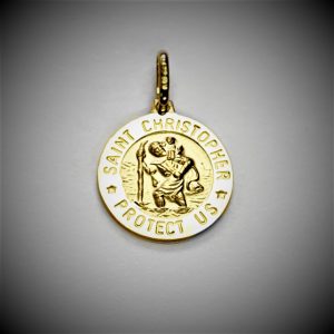 Christian gold pendant with a dark background.