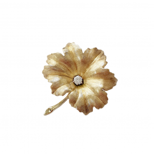 Textured yellow gold leaf brooch pin set with a single sparkling white diamond to the centre.