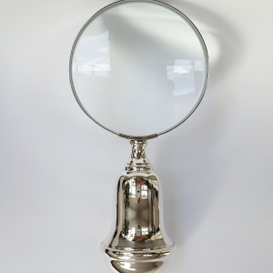 Front-facing magnifying glass against a neutral grey backdrop, showcasing its circular lens and polished silver rim with crisp clarity.
