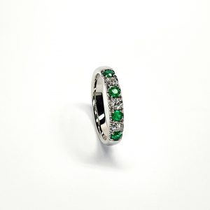 18ct White Gold Emerald & Diamond Eternity Ring RA00685 Four 2.8mm round emeralds and three 2.8mm round diamonds ring standing up to the front angled facing to the right. With a white background.