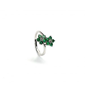 Double Cluster Emerald Ring. Crafted in 18ct white gold featuring two clusters of five round bright green emeralds with a single diamond to the centre of each cluster, with a wave cross over shank