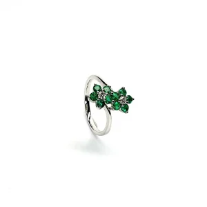 Double Cluster Emerald Ring. Crafted in 18ct white gold featuring two clusters of five round bright green emeralds with a single diamond to the centre of each cluster, with a wave cross over shank